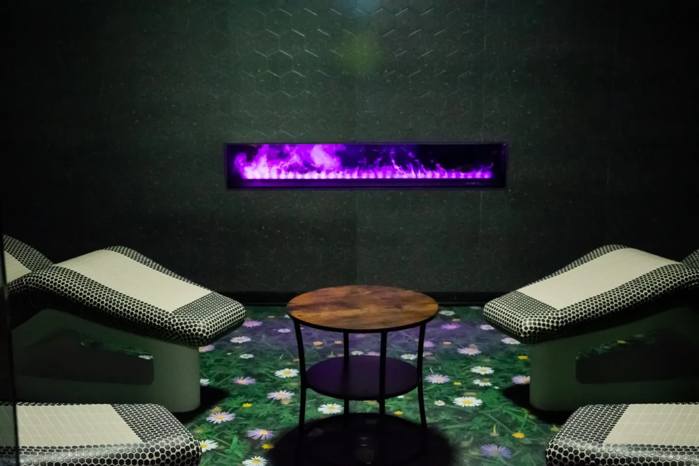 Odpočinková zóna s lehátky a elektrickým krbem ve wellness Hotelu Raj