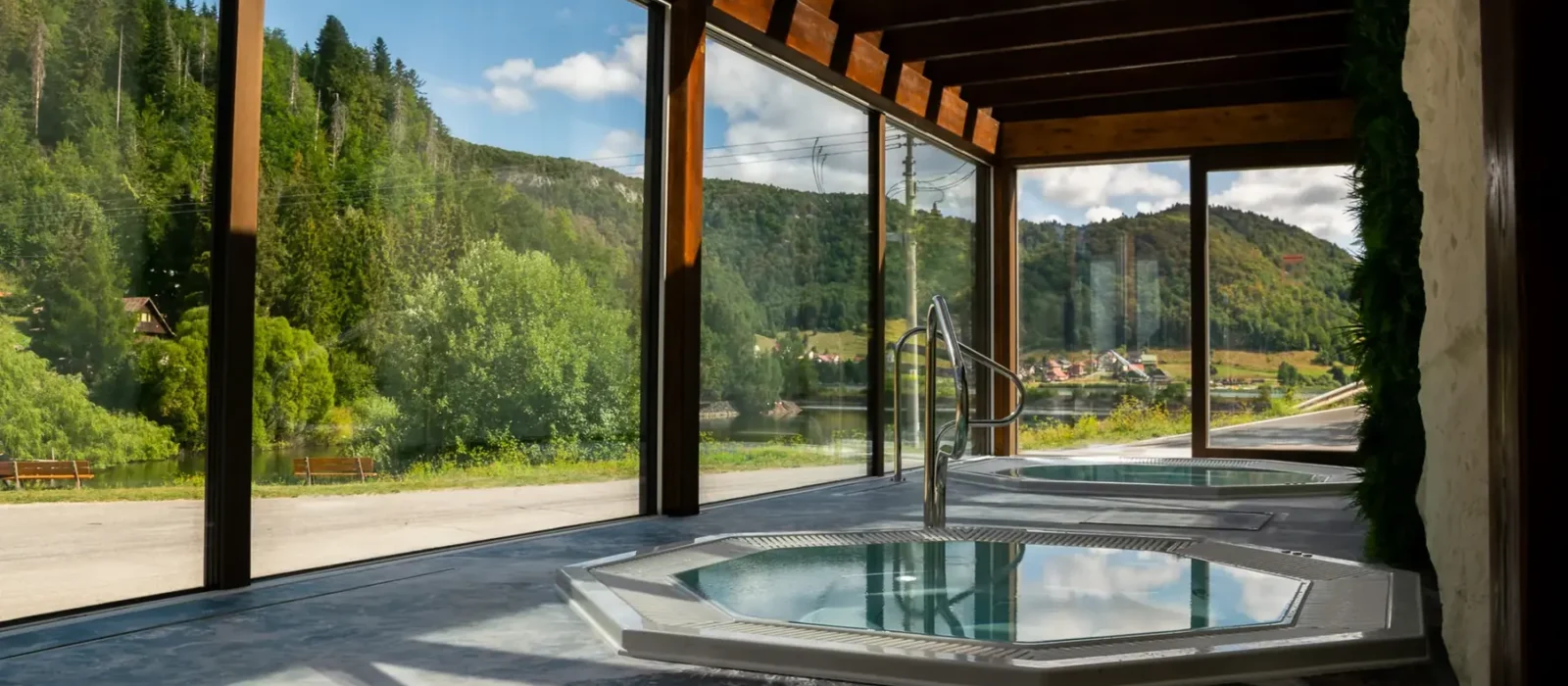 Wewnętrzne jacuzzi w strefie wellness Hotelu Raj z panoramicznym przeszkleniem i widokiem na zalew Palcmanská Maša